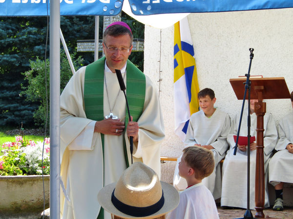 Kinder erzählen dem Bischof, was sie beim Familiencamp erlebt haben.